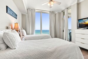 Ein Hotelzimmer mit Bett, Fernseher und Meerblick.