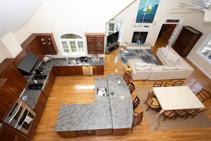 Un salón amplio con cocina, mesa de comedor y asientos.