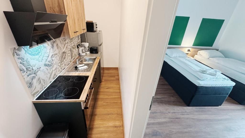 A compact kitchenette with a stove, sink, and microwave.