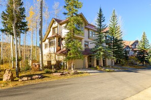 A two-story house with a stone facade, a front porch, and a garage. - The Alpine Nest 3 Bedroom Townhouse (Telluride)