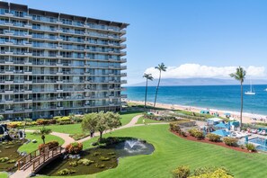 A multi-story hotel with balconies, a pool area, and a view of the beach. - Whaler 413 Oceanview Studio Condo Apts (Lahaina)