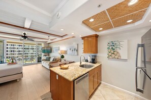 Une cuisine moderne dotée d’un îlot central, de meubles en bois et d’un réfrigérateur en acier inoxydable.