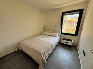 A bedroom with a single bed, a window, and a small bedside table. - Foça Taş Villa (foça)
