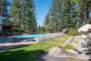 A swimming pool with lounge chairs and umbrellas, surrounded by trees. - 3388 Pine Hill Road 2 Bedroom Home (South Lake Tahoe)