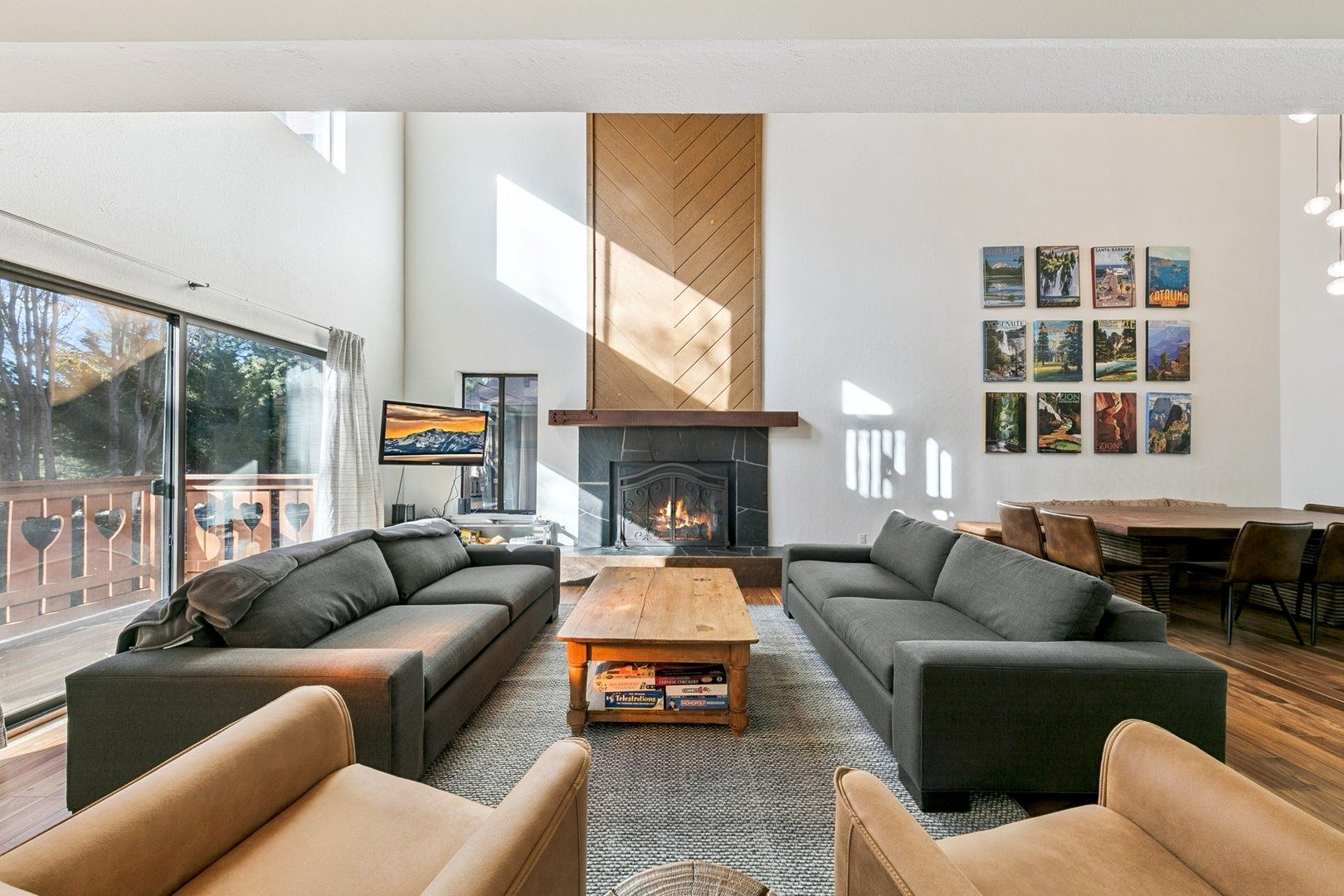 A modern living room with a fireplace, sofas, a coffee table, and a TV.