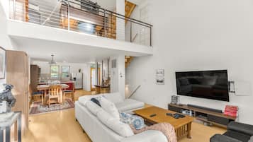 Un salón amplio con techo alto, comedor y cocina.