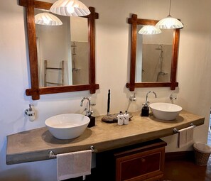 A bathroom with two sinks, a mirror, and a towel rack.