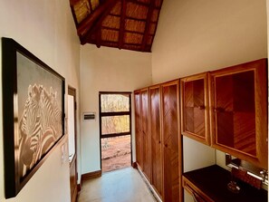 A hallway with wooden cabinets, a framed picture, and a door leading to an outdoor area.
