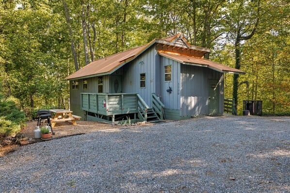 A rustic cabin with a metal roof, surrounded by trees. - Hideaway Overlook 1 Bedroom Cabin (Sevierville)