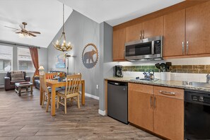 A modern kitchen with wooden cabinets, a built-in microwave, and a dishwasher. - Premium Unit 3623 - 1 Br W/kitchenette 1 Bedroom Condo (Winter Park)