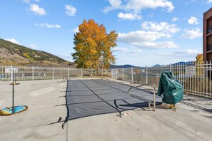 Une terrasse sur le toit avec un espace piscine, comprenant une table de billard et une partie abritée.