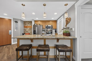 A modern kitchen with a central island, stainless steel appliances, and pendant lighting. - Premium Unit 3301 - Two Bedroom - Fraser Crossing/Founders Pointe 2 Condo (Winter Park)