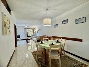A dining area with a round table, chairs, and a ceiling fan. - Albufeira Typical 2 by Homing (Albufeira)