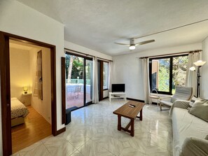 A spacious living room with a flat-screen TV, a wooden coffee table, and a sofa. - Albufeira Typical 2 by Homing (Albufeira)