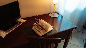 Ein Schreibtisch mit einem Laptop, einem Glas Wasser und einer Papierstapel.