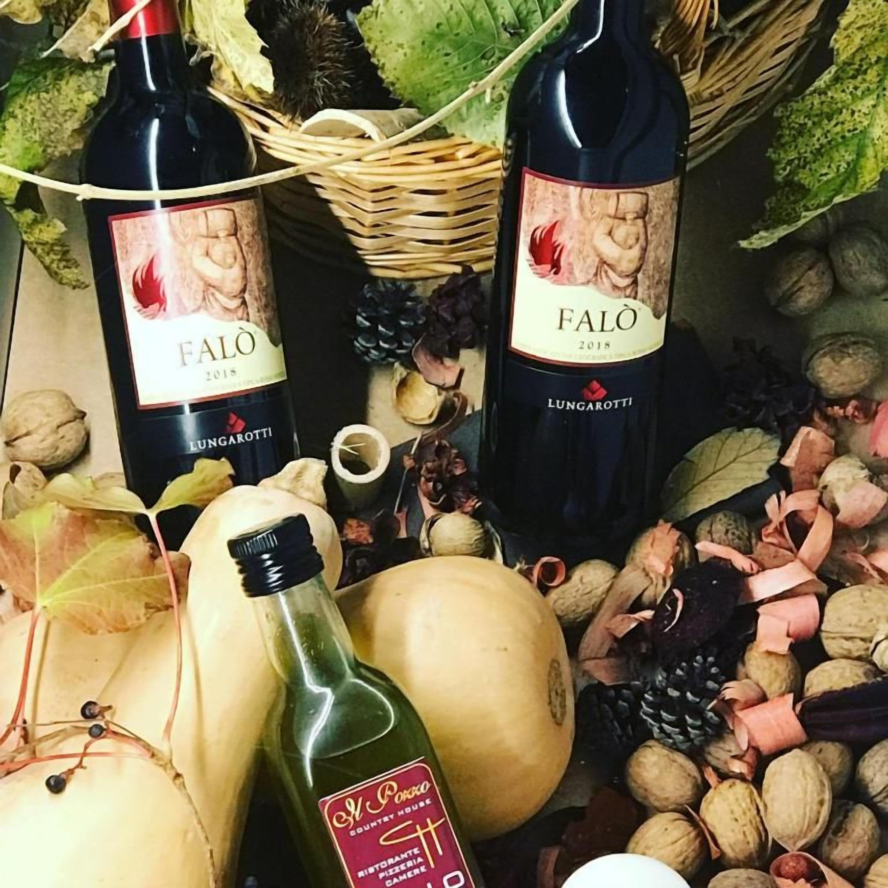 To flasker Falò vin fra 2018, omgivet af forskellige nødder og græskar.
