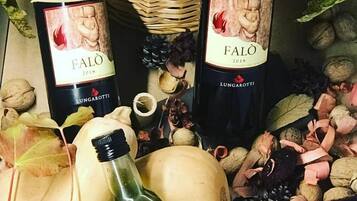To flasker Falò vin fra 2018, omgivet af forskellige nødder og græskar.