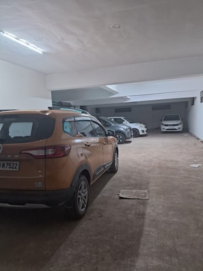 A parking garage with multiple cars parked in rows. - SPH Comforts (Bhogadi)