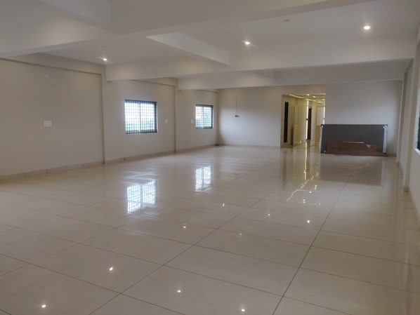 A spacious, empty room with a high ceiling and a polished floor. - SPH Comforts (Mysore)