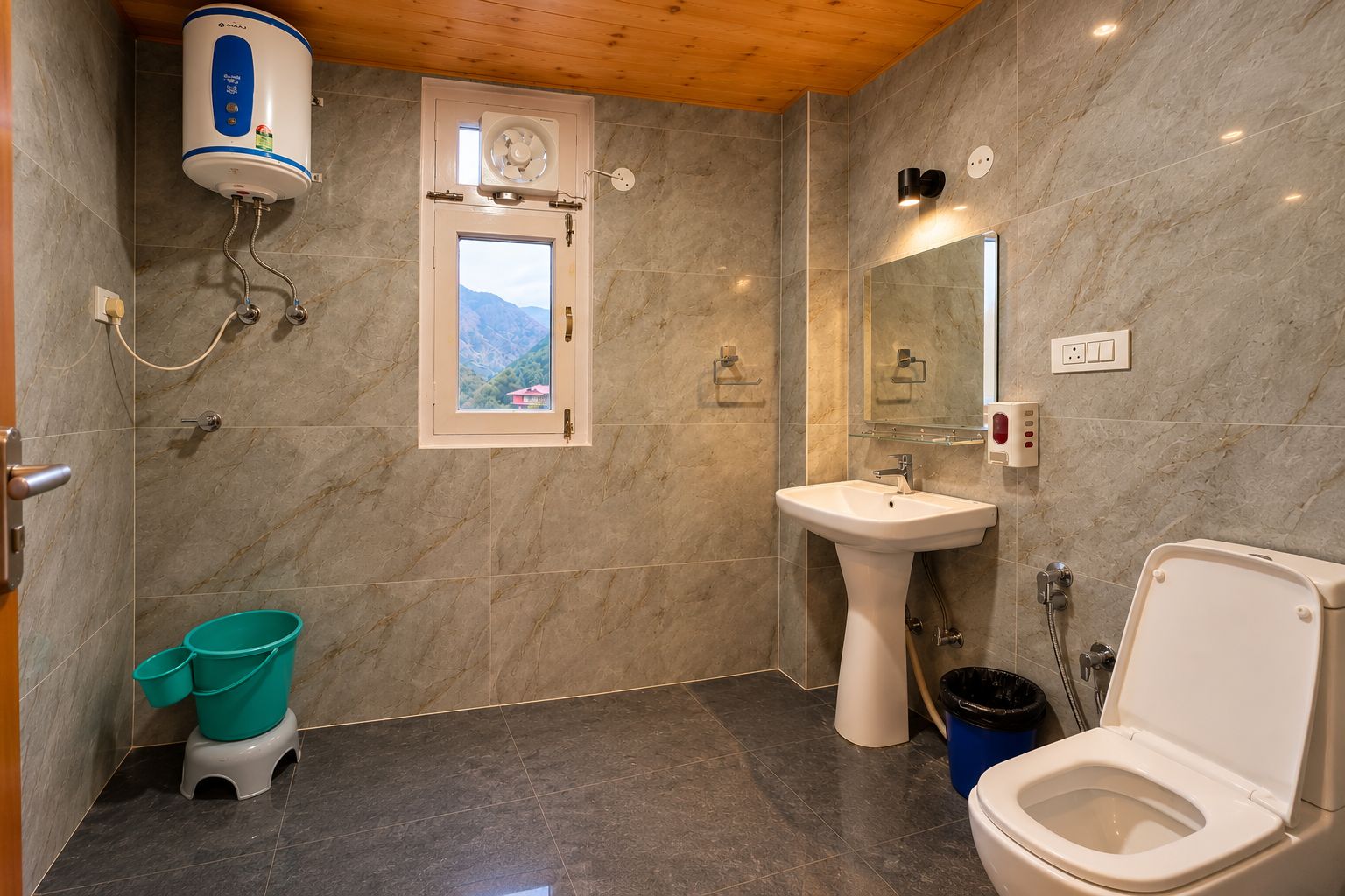 Une salle de bain équipée d’une douche, de toilettes, d’un lavabo et d’une fenêtre donnant sur les montagnes.