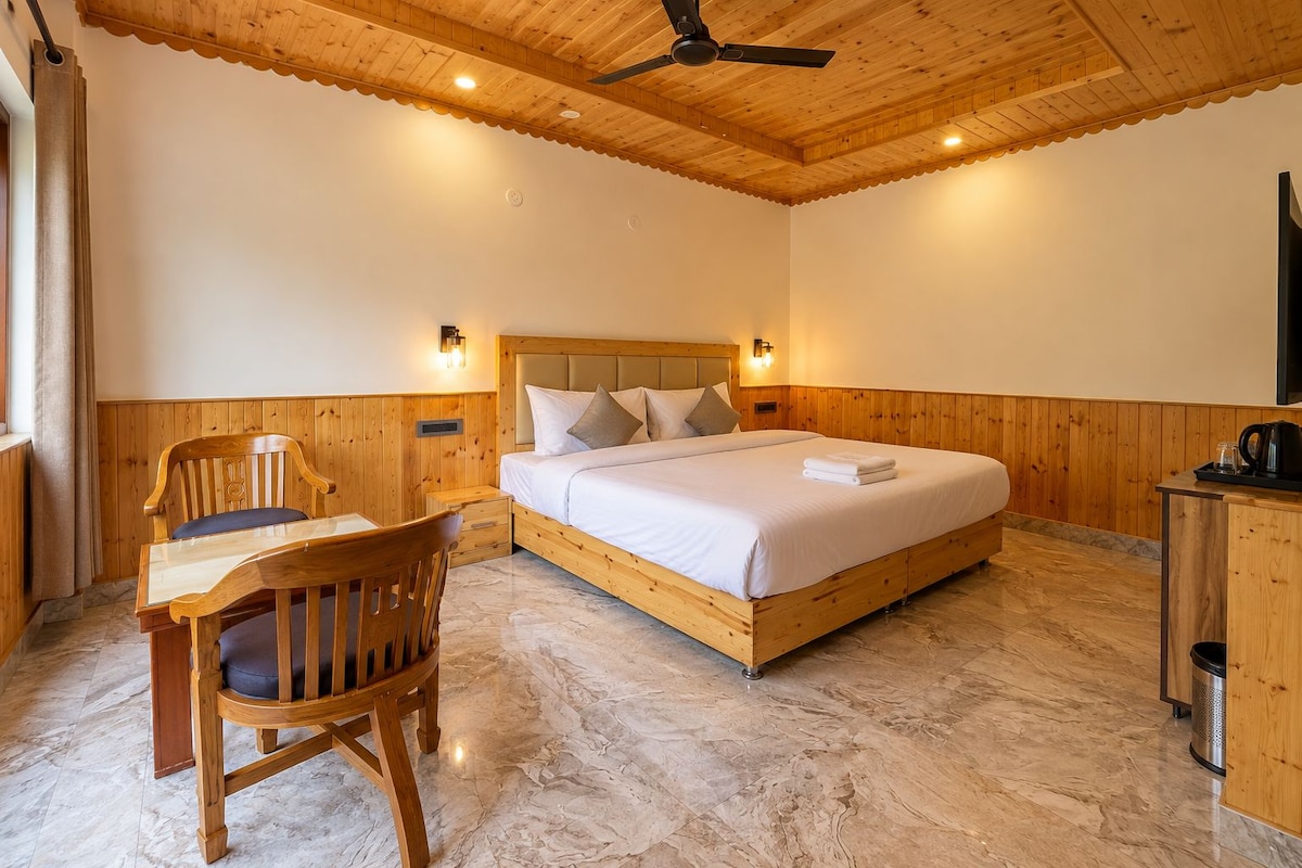 A bedroom with a wooden bed, a desk with a chair, and a ceiling fan.