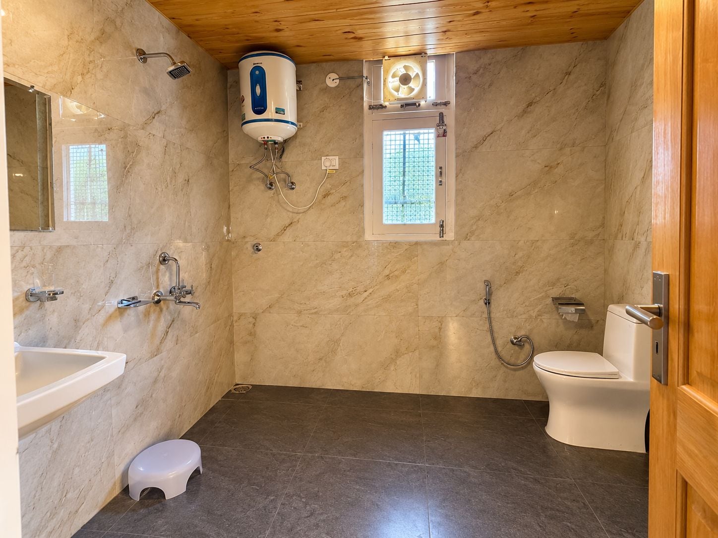 A bathroom with a toilet, shower, and sink.