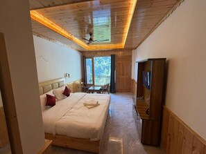 Un dormitorio con cama, televisión y vistas al exterior.