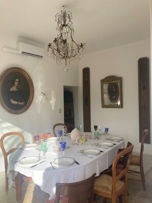 A dining area with a round table set for four, surrounded by wooden chairs. - Bastide de l'Aven with a pool—within walking distance of Aups, in an olive grove (Aups)