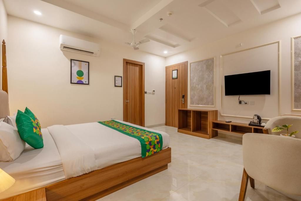 Una habitación de hotel con cama, televisión, escritorio y silla.