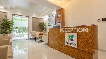 Una zona de recepción con un mostrador de recepción que indica 'RECEPTION' y el logotipo de 'treebo'.