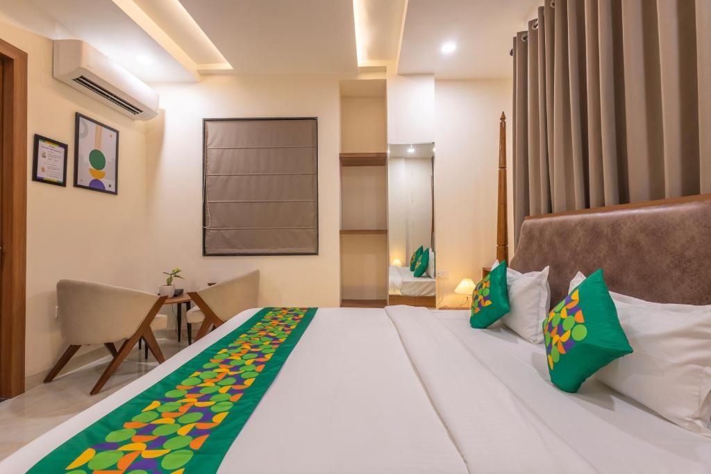 A hotel room with a bed, a desk, a chair, and a window with curtains.