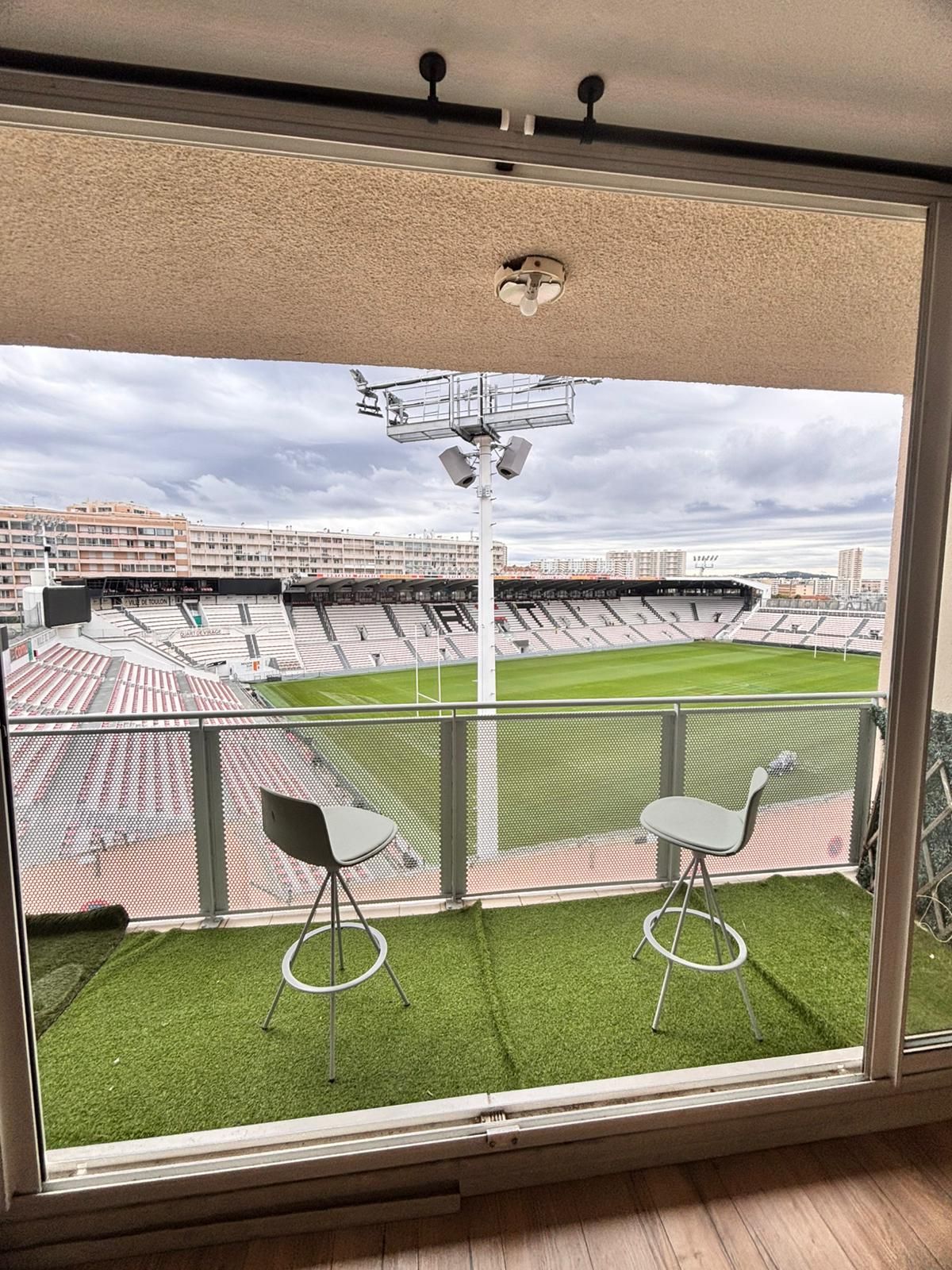 A room with a large window overlooking a stadium.