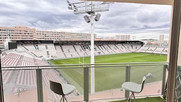 Une pièce dotée d’une grande fenêtre donnant sur un stade.
