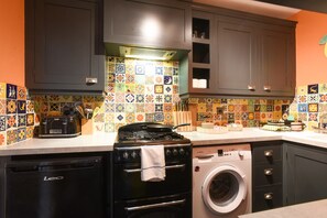 A kitchen with a Bosch gas stove, a washing machine, and a dishwasher. - Cosy One-Bedroom Flat in Southsea (Portsmouth)