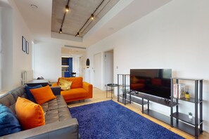 A modern living room with a sofa, a flat-screen TV, and a coffee table. - Vibrant 1BR Flat w/ great views -Excel, O2, Canary (London)