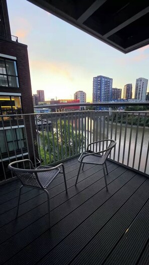 A balcony with two chairs and a view of a city skyline at sunset. - Vibrant 1BR Flat w/ great views -Excel, O2, Canary (London)