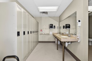 A hotel bathroom with lockers, a sink, a mirror, and a hairdryer. - Gorgeous 3 bedroom on Eagle River chain of lakes with indoor pool and jacuzzi (Eagle River)