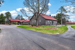 A residential building with a red roof, multiple windows, and a well-maintained lawn. - Eagle River Chain Condo with Indoor Pool and Jacuzzi! (Eagle River)