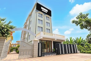 A multi-story hotel with a prominent sign, a gated entrance, and a balcony. - Palette Hotel and Resort Mayapur (Mayapur)