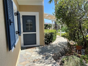 A house with a stone pathway leading to a door with a window. - Country House 'Iron Hill Villa' with Sea View, Wi-Fi and Air Conditioning (Κρανίδι)