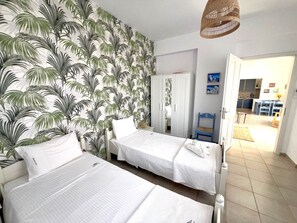 A bedroom with two single beds, a wardrobe, and a view into the dining area. - Country House 'Iron Hill Villa' with Sea View, Wi-Fi and Air Conditioning (Κρανίδι)
