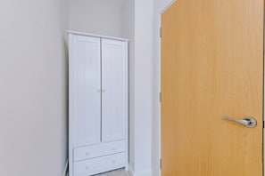 Armari blanc amb dos calaixos i una porta de fusta amb mànec.