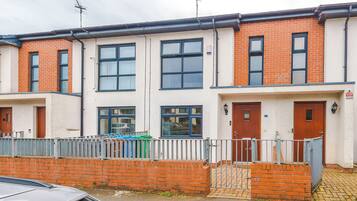 A row of terraced houses with brick facades, multiple windows, and a gated entrance.