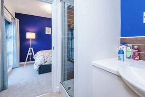 A bedroom with a bed, a standing lamp, and a window with curtains. - 3-Bed House, Close to City Centre & UoM (Manchester)