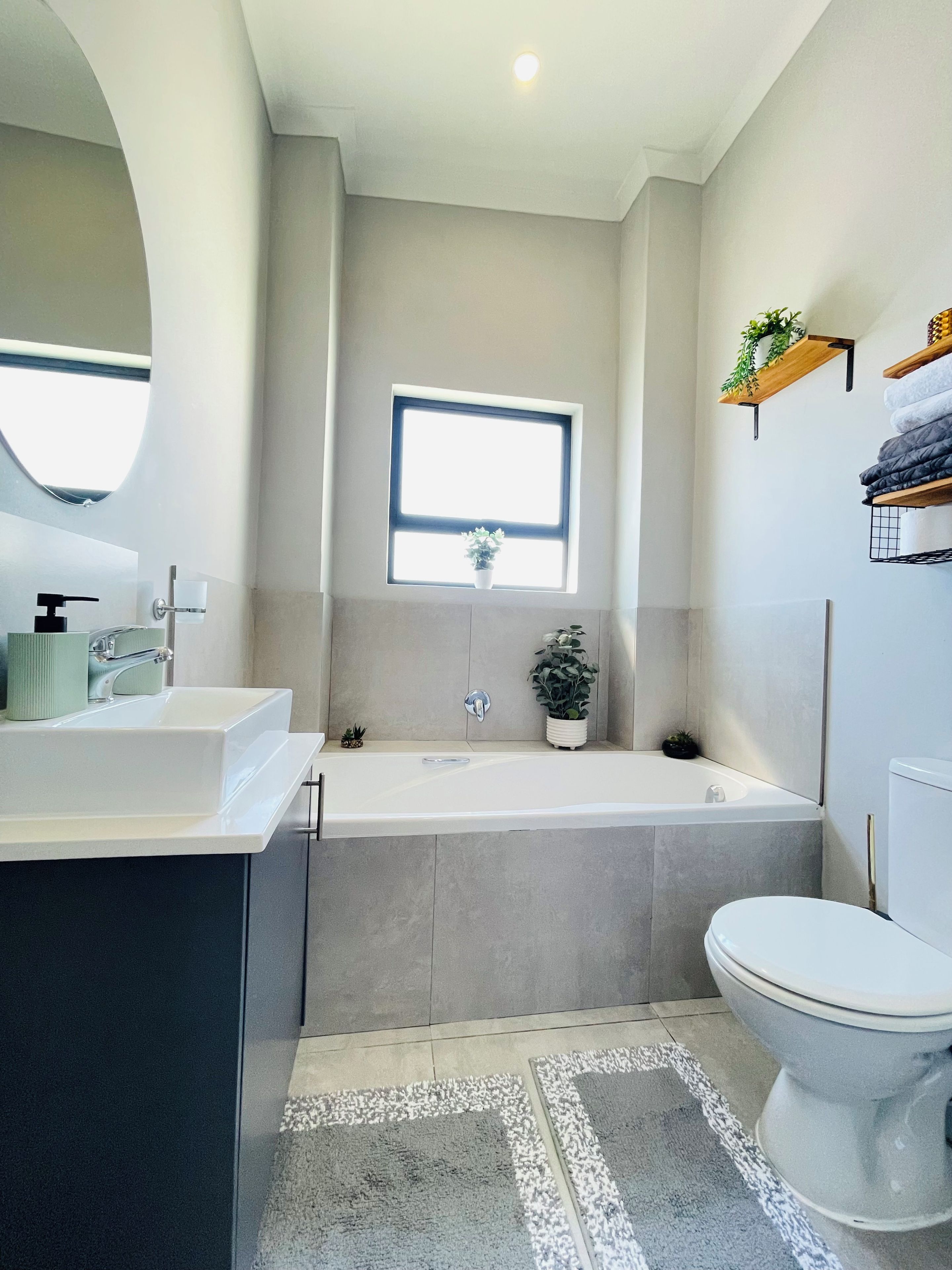 A modern bathroom with a bathtub, toilet, and sink.
