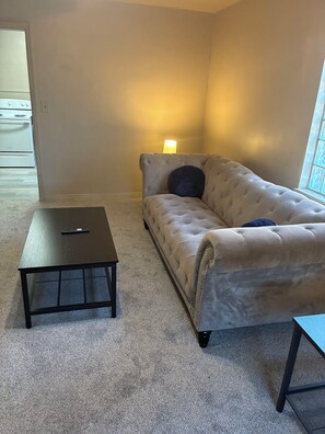 A room with a beige sofa, a small black coffee table, and a lamp. - Spacious 4-bedroom house in peaceful Cincinnati 5 minutes to downtown (Cincinnati)