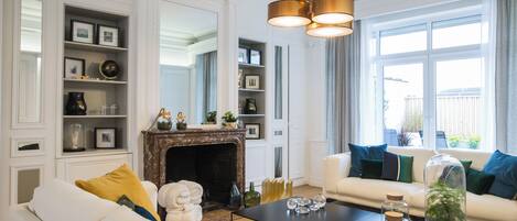 A living room with a fireplace, a sofa, a coffee table, and a bookshelf.