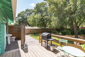 A wooden deck with a barbecue grill and a picnic table. - Iconic Coastal retreat close to Siesta Key Beach! (Sarasota)