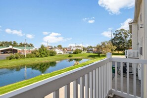 A residential area with a water body, a white fence, and houses in the background. - Fighting Irish Retreat | 3BR/4BA (South Bend)