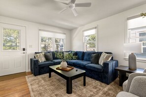 A living room with a dark blue sectional sofa, a coffee table, and a floor lamp. - 3BR/1BA Updated South Bend Retreat Close to ND (South Bend)